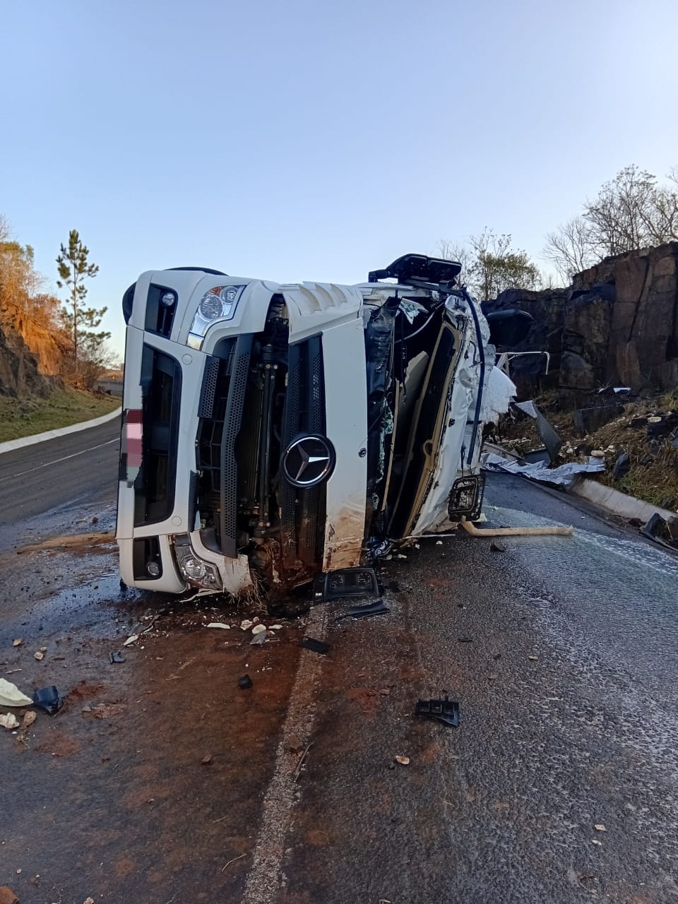 Caminhão carregado de leite capota na BR-282 em Paraíso e motorista fica preso nas ferragens